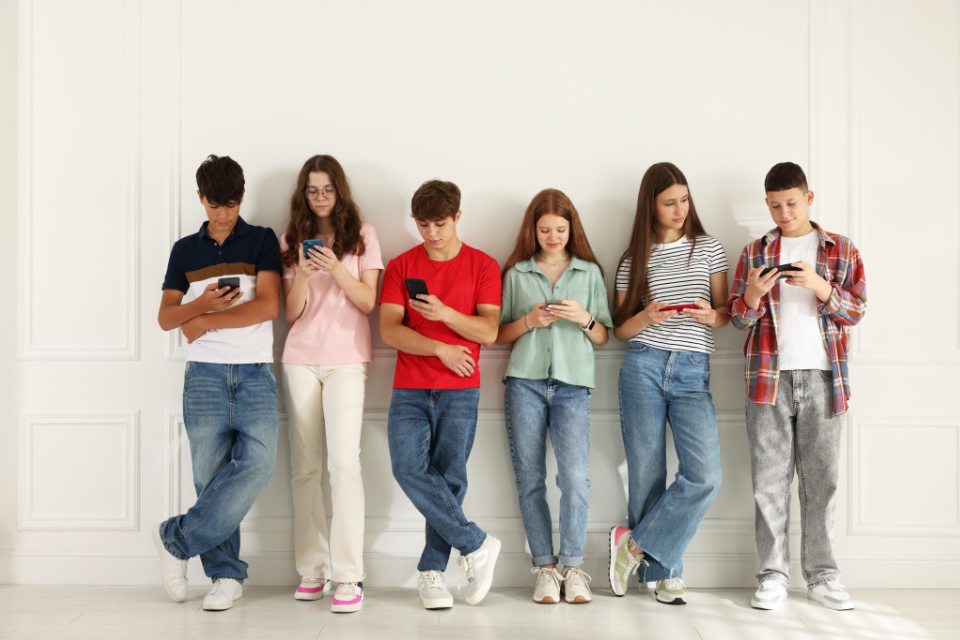 Line of Teenagers on Mobiles Phones