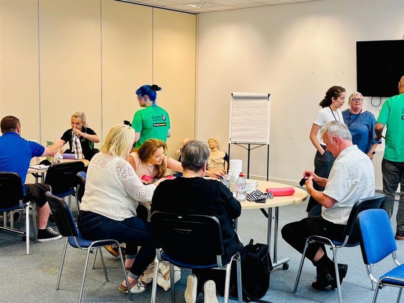Room full of people sat at wooden circular tables