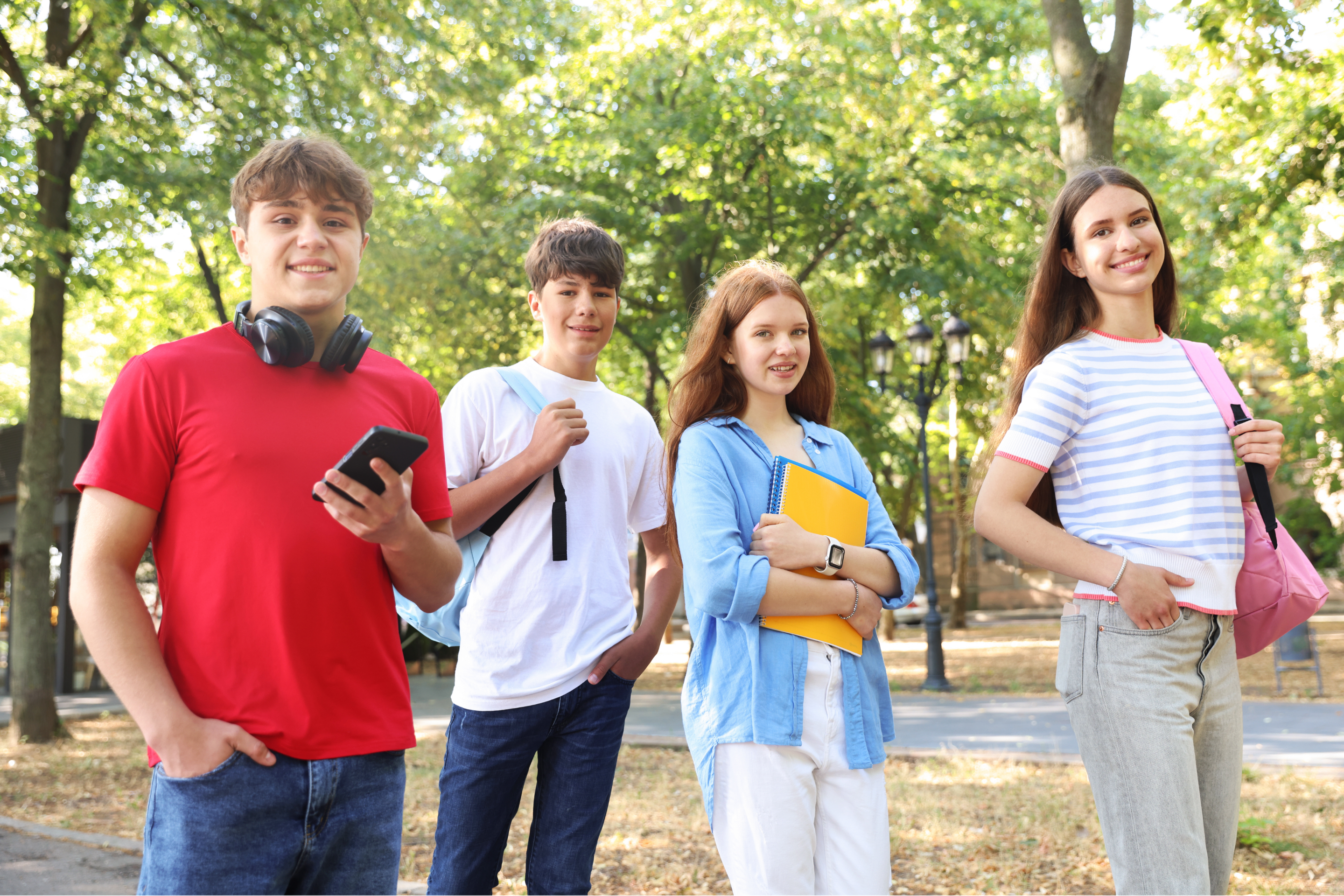 Teenagers Outdoors with Books and Headphones